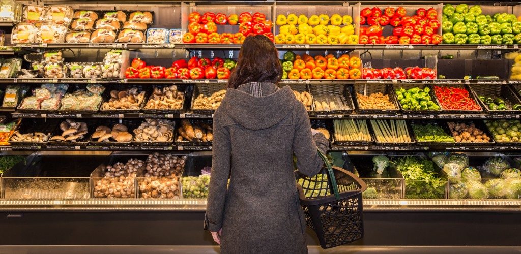 Woman holding basket while grocery shopping