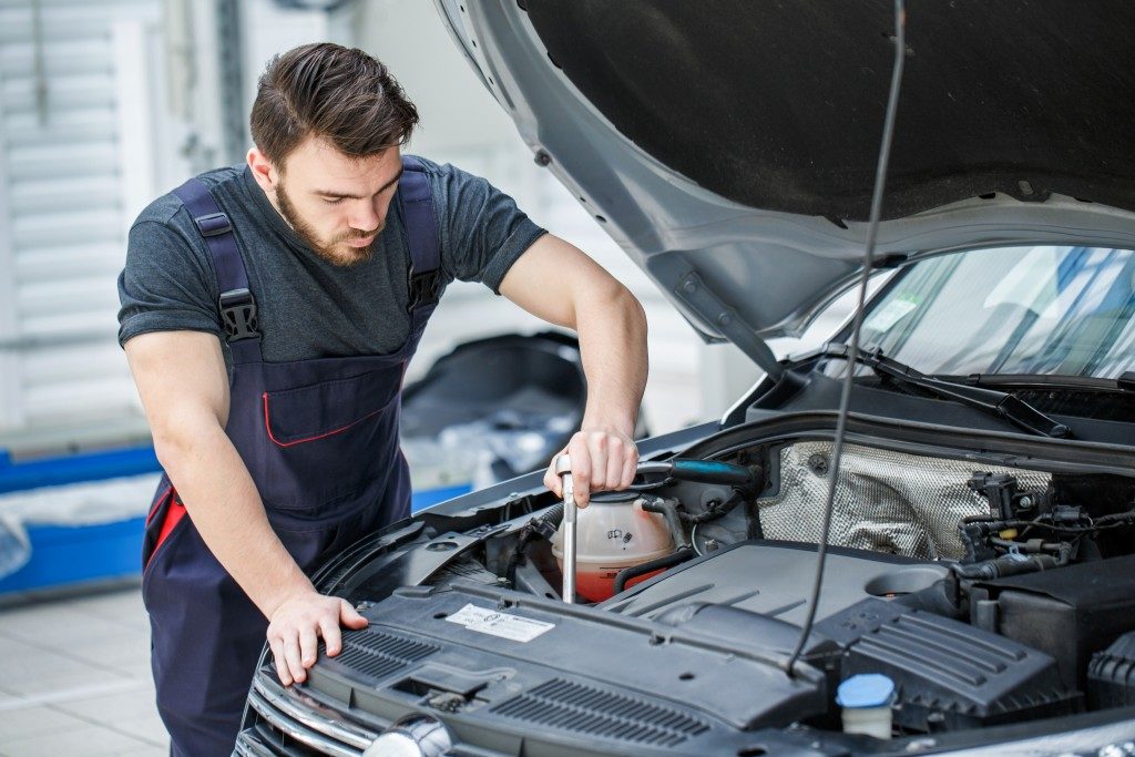 mechanic repairing car engine