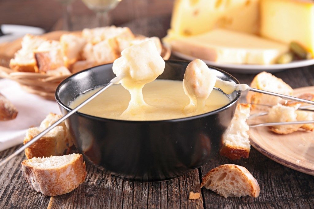 bread being dipped in cheese