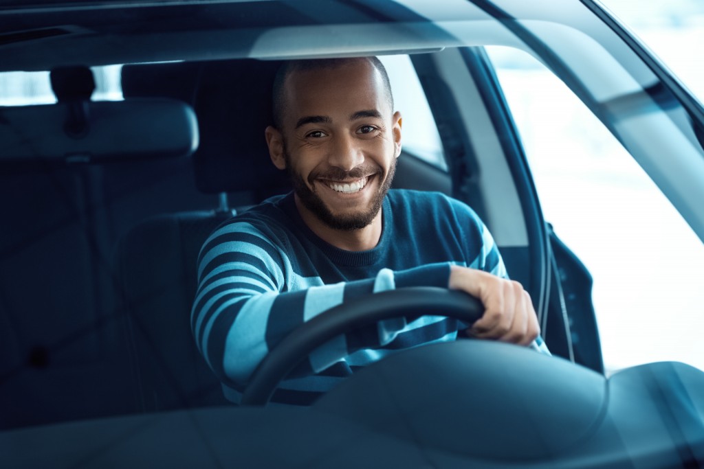man smiling while driving car