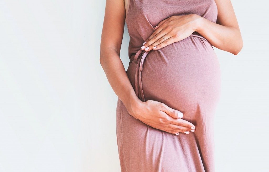 woman holding her pregnant tummy