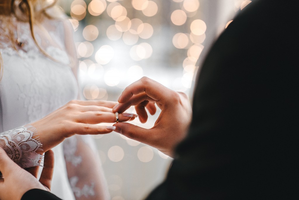 Man placing ring on woman's finger