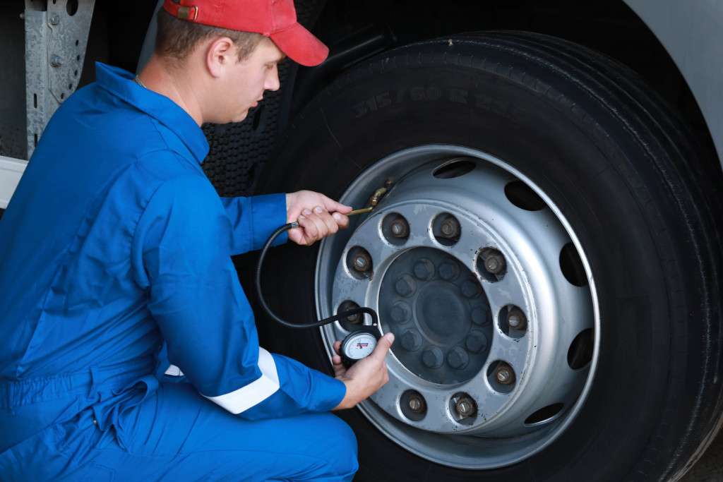 man uisng air compressor on a tire