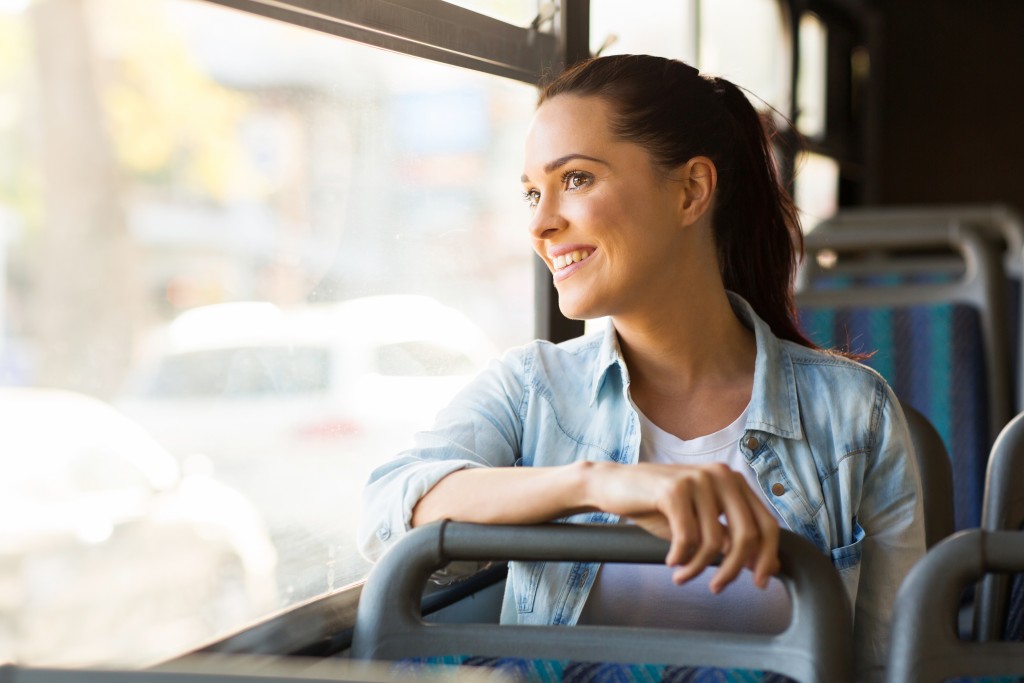 woman looking out the window riding a bus