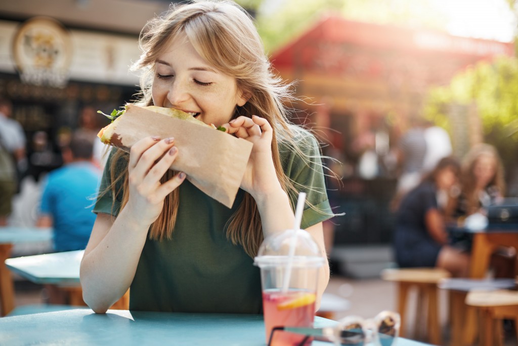 woman eating in a food park