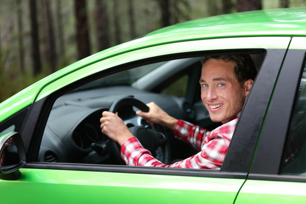 a man on a green car ready to drive passengers